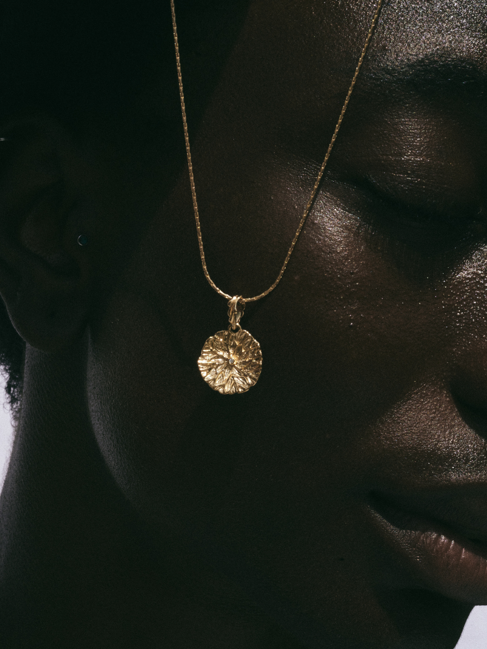 Carina Hardy fine yellow gold Lilypad Pendant Necklace on a model, zooming in to the elegance and sophisticated craftsmanship.