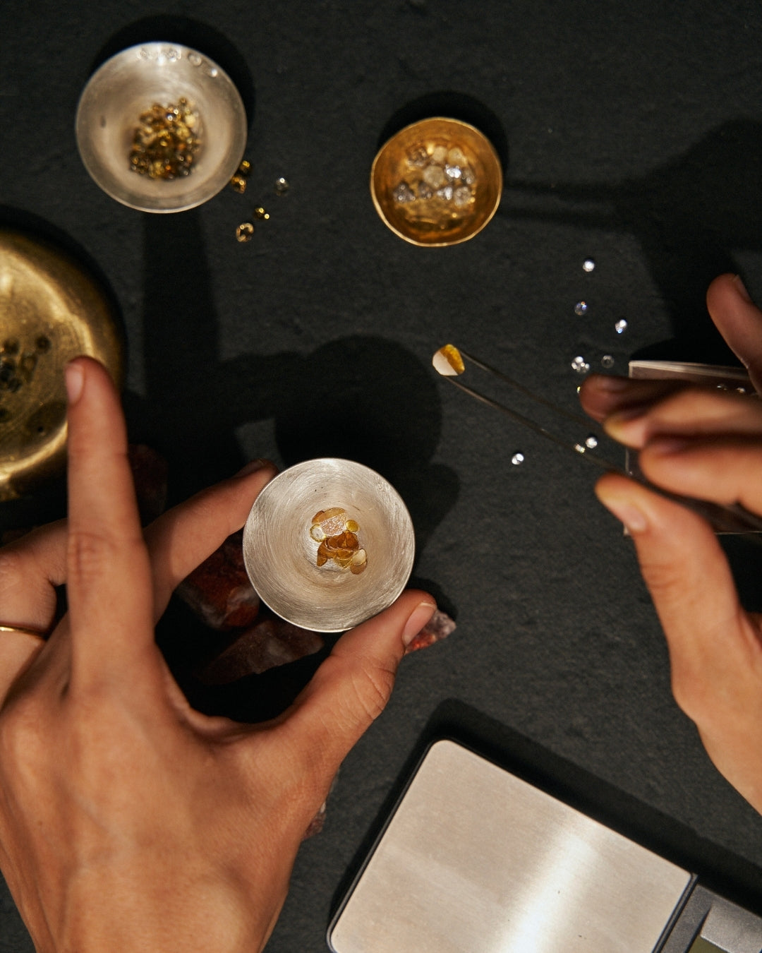 Arrangement of stones and ornaments used in creating Carina Hardy fine jewelry. Intricate production process. View the collection today.