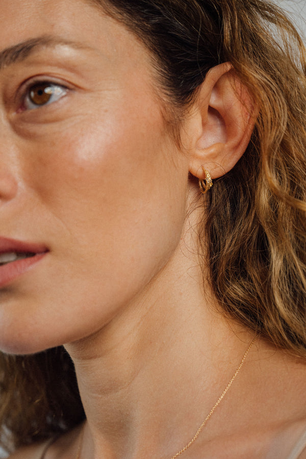 Recycled 18K yellow gold crescent hoop earring that loops together below the lobe, pavé set with brown diamonds and yellow sapphires.