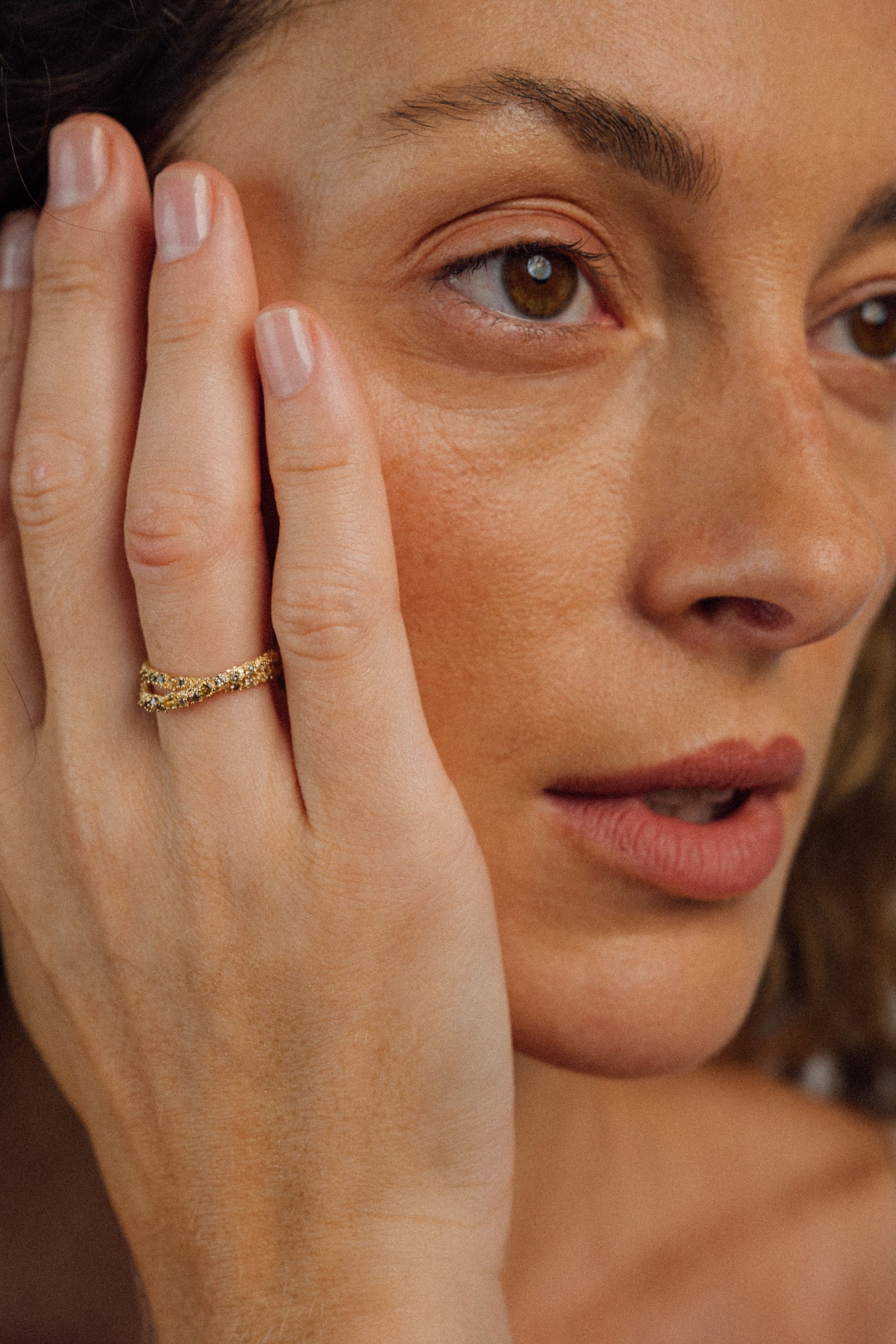 ecycled 18K yellow gold crossover ring with two pavé-set bands of brown diamonds and yellow sapphires, entwined at the top and joined into one band at the bottom. Handcrafted in Bali with stones set in Bangkok.
