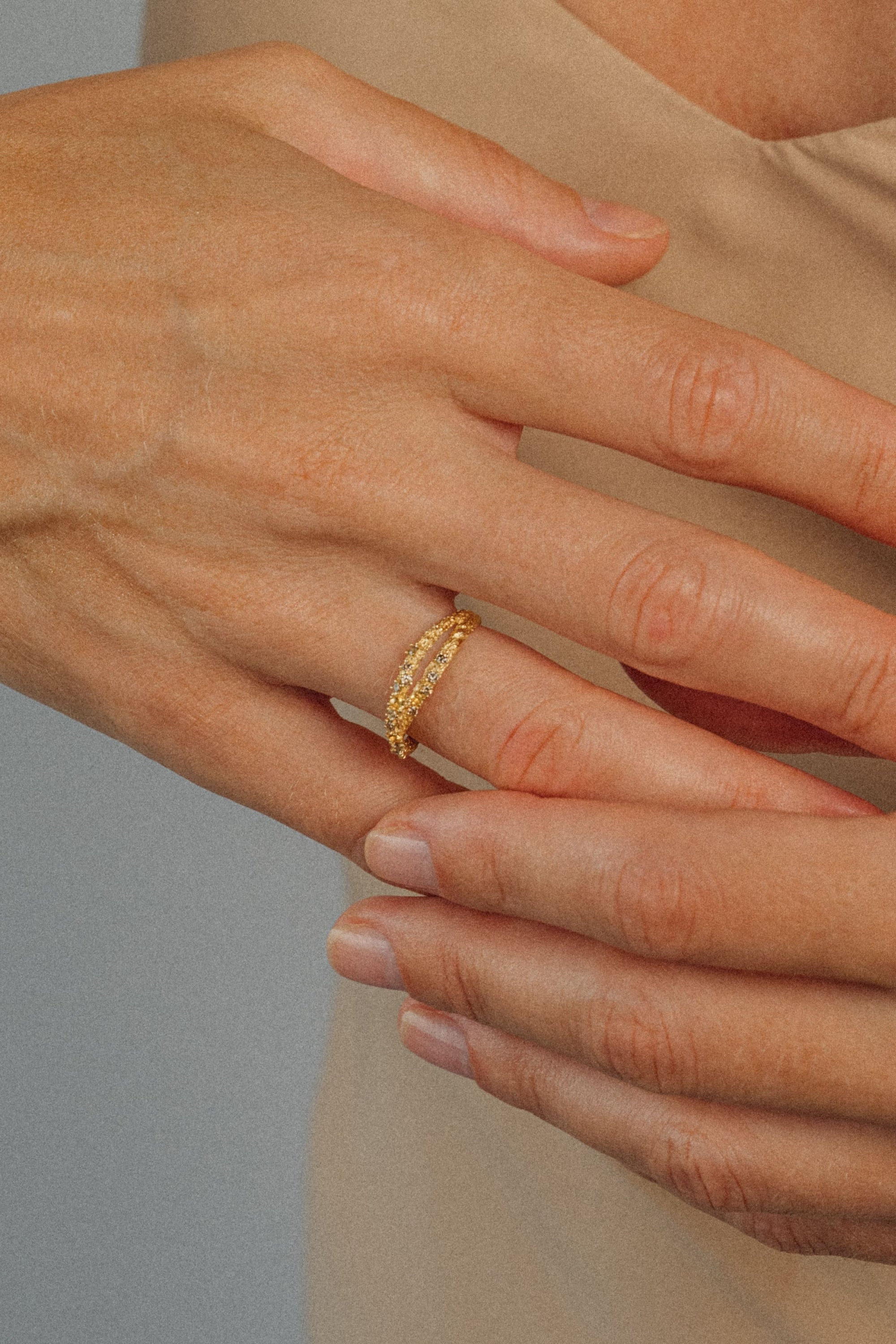 ecycled 18K yellow gold crossover ring with two pavé-set bands of brown diamonds and yellow sapphires, entwined at the top and joined into one band at the bottom. Handcrafted in Bali with stones set in Bangkok.
