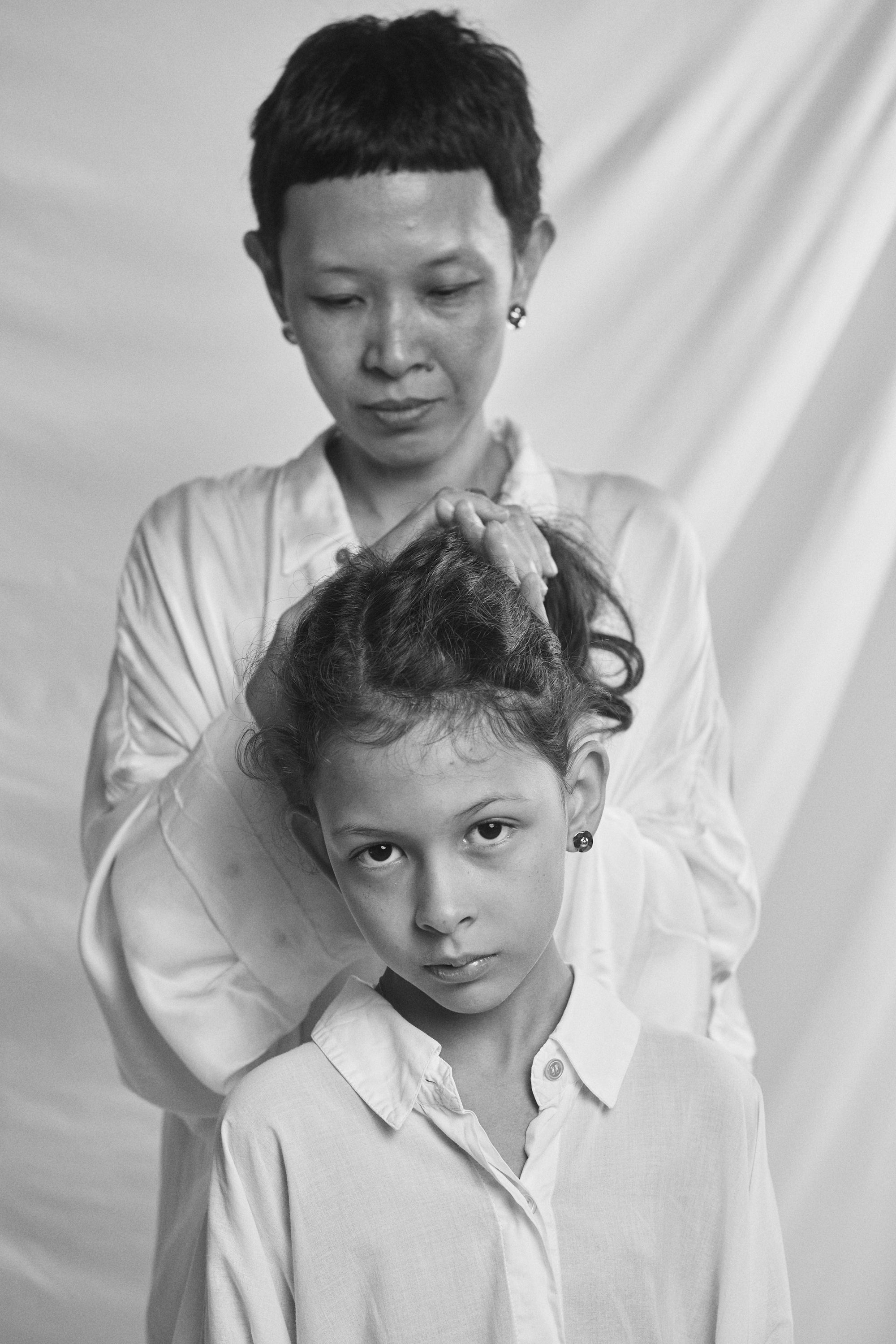 Black and white portrait of a mother and daughter with Carina Hardy fine yellow gold jewelry. Celebrating the bond between mother and child. View the collection today.