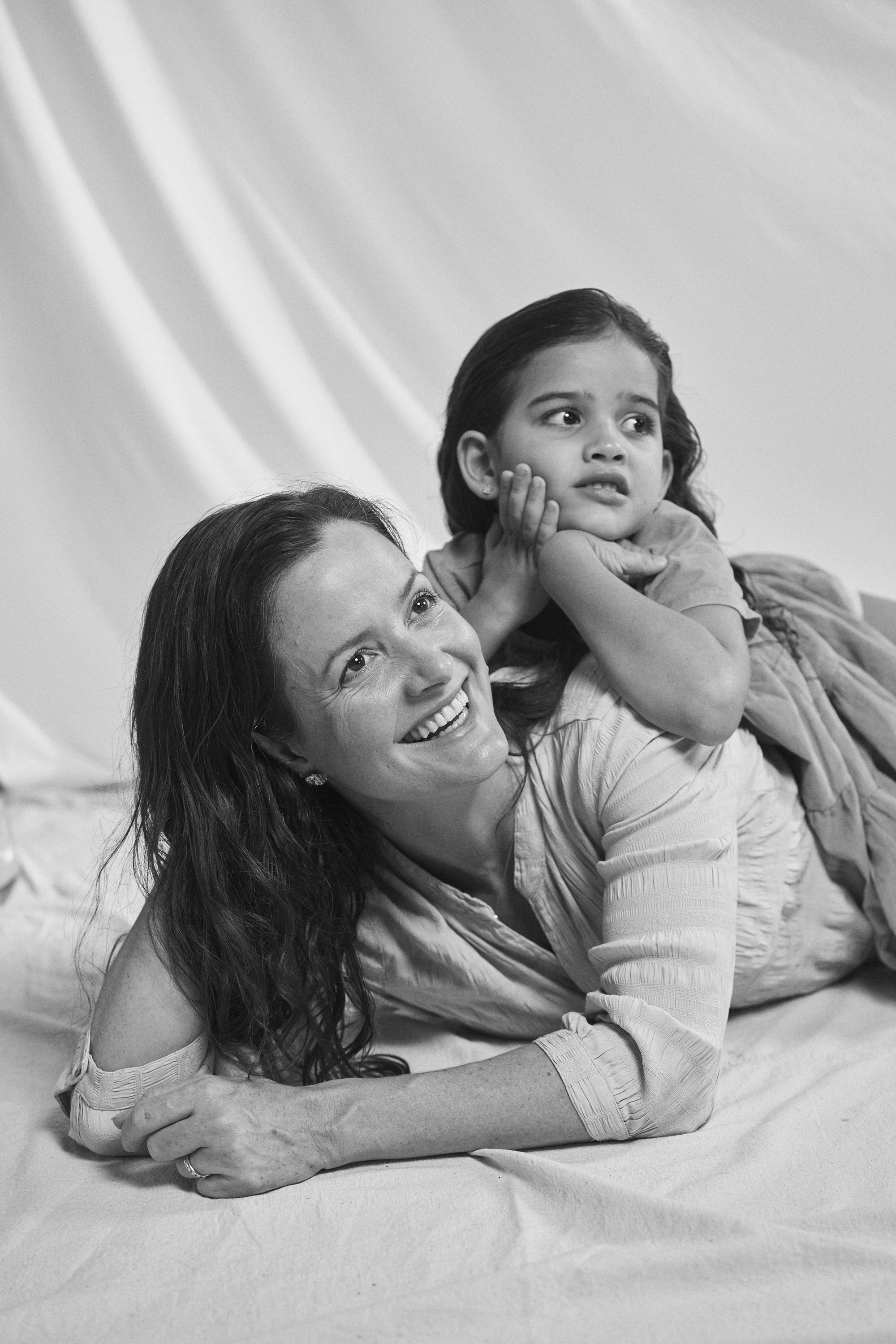 Black and white portrait of a mother and daughter adorned by Carina Hardy fine yellow gold jewelry. View the collection today.