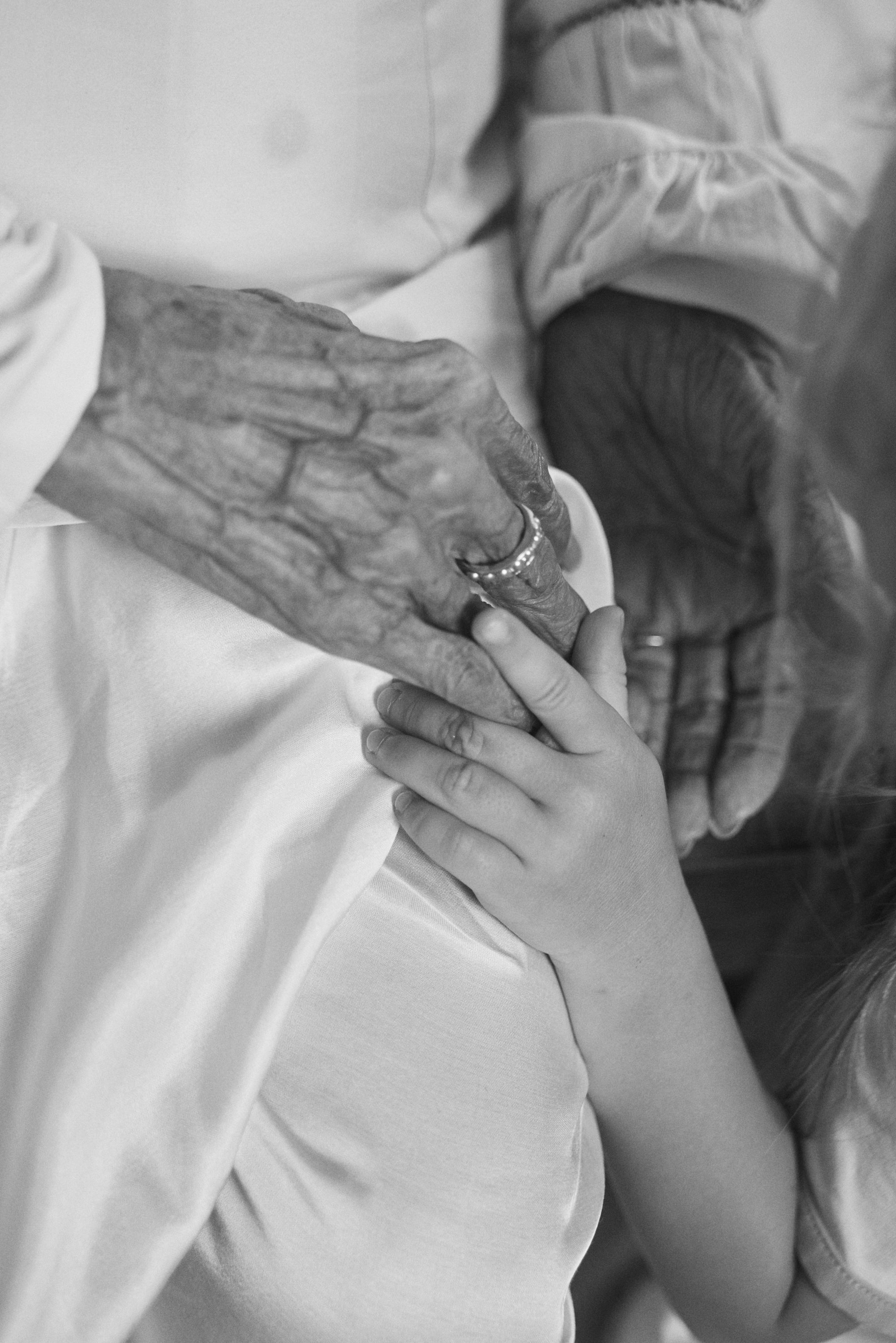 Black and white picture of a mother and daughter holding hands, showcasing Carina Hardy fine yellow gold Mother ring, inspired by women and their bonds.