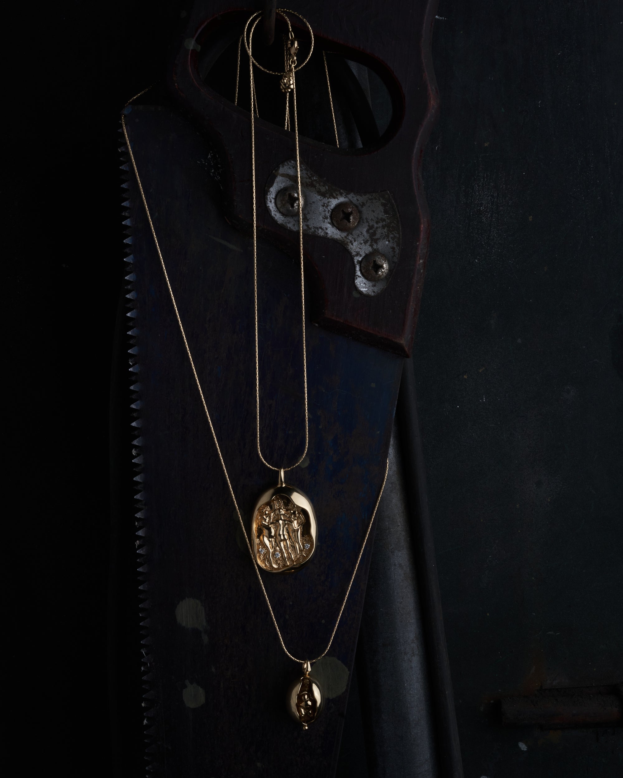 Layered necklaces from the Carina Hardy fine yellow gold jewelry collection, displayed against a dark background. View the collection today.