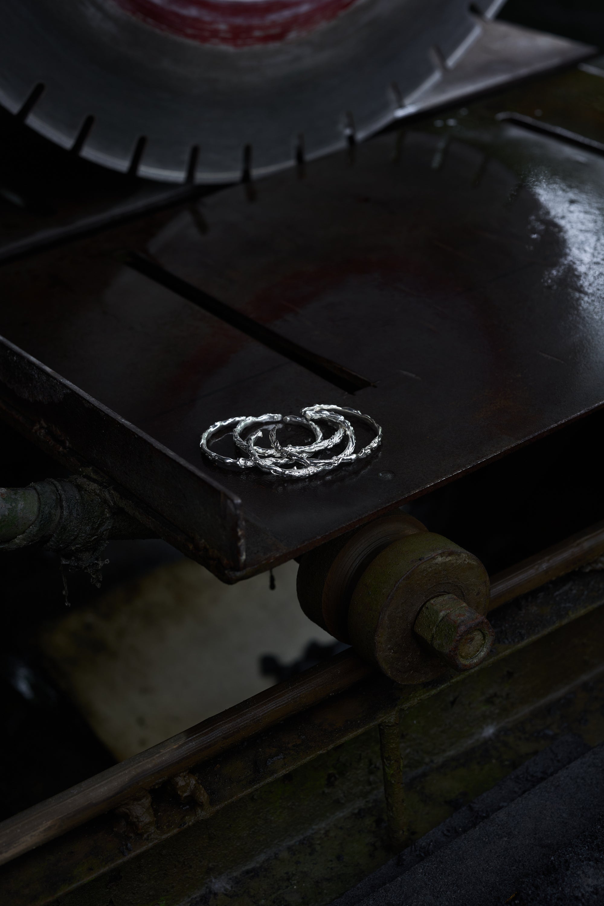 Close-up of a Carina Hardy precious sterling silver cuff being crafted on a jeweler’s workbench. Detailed craftsmanship highlighted. View the collection today.