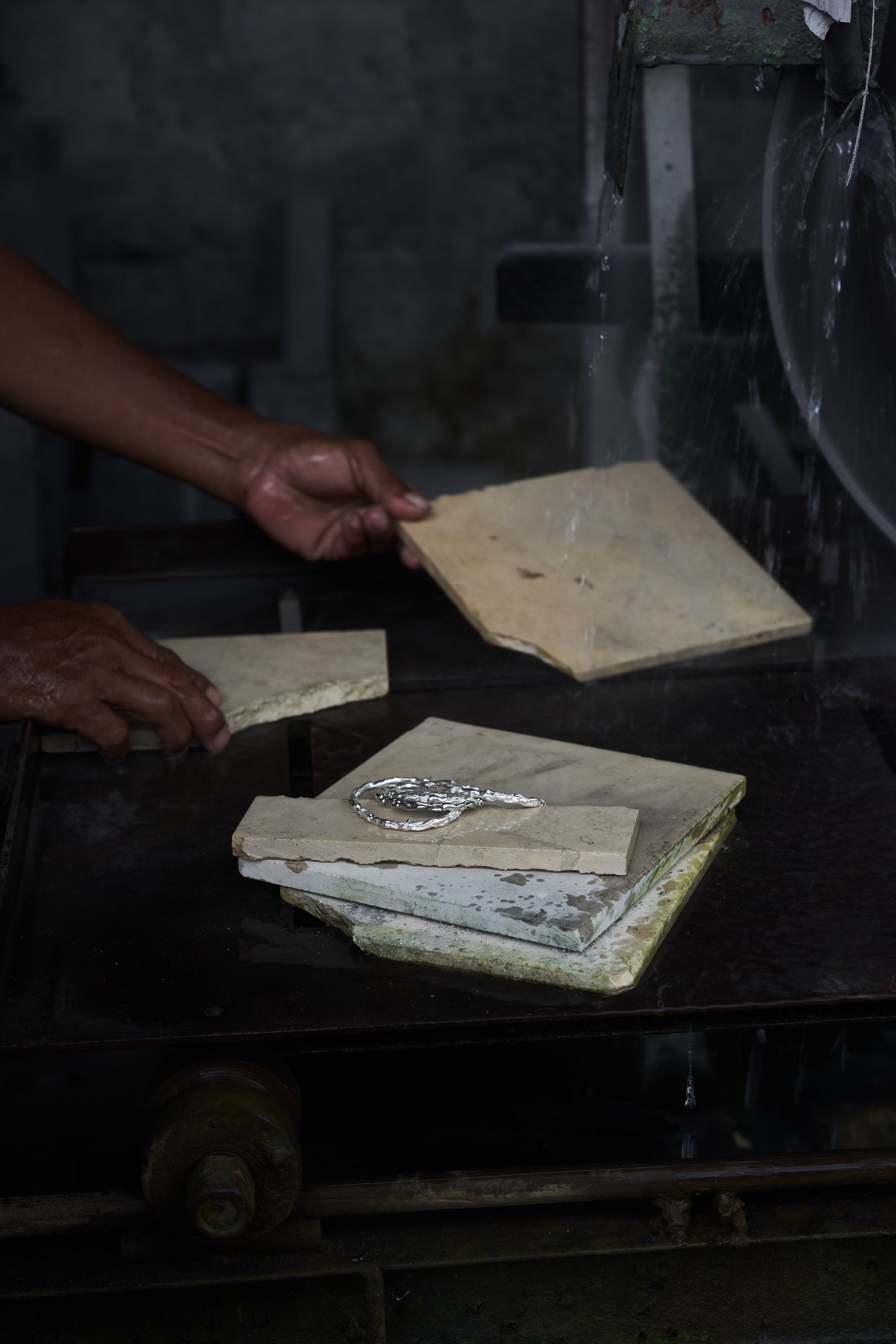 Jeweler choosing tiles as a backdrop for Carina Hardy precious sterling silver jewelry, highlighting the creative process behind the scene. View the collection today.