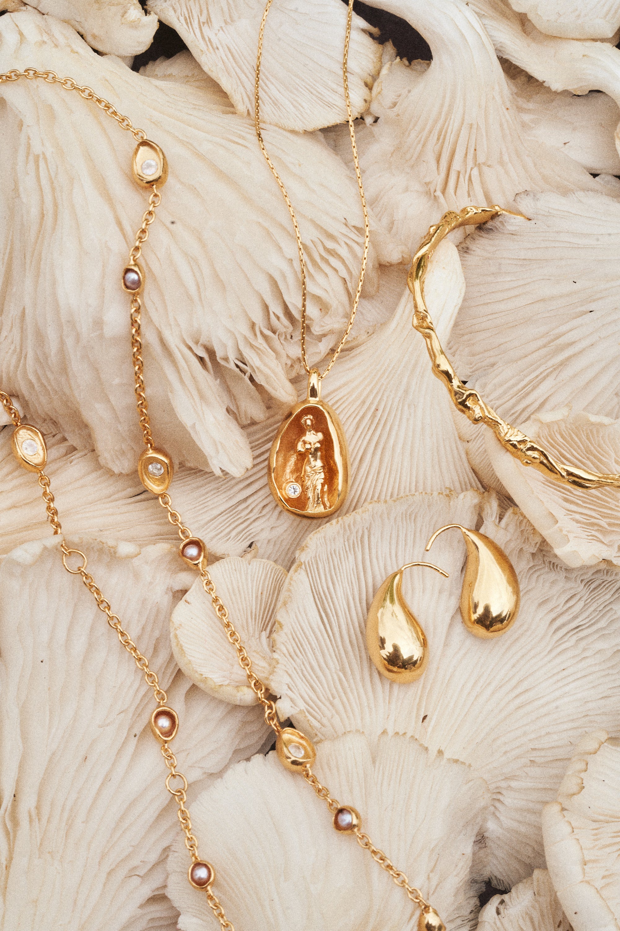 Carina Hardy fine sterling silver gold plated Showers Necklace arranged on a white mushroom background. Intricate and luxurious design. View the collection today.