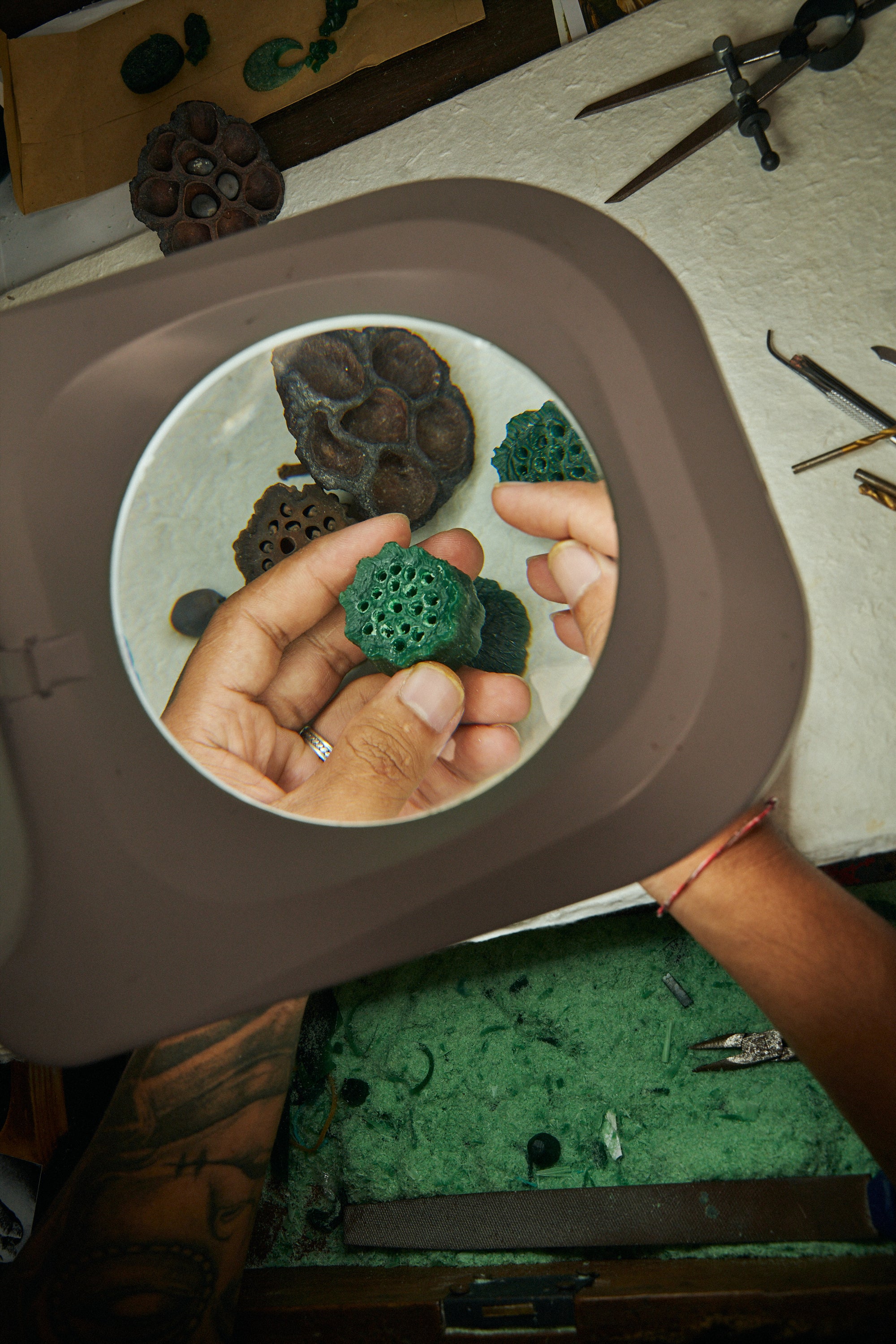 Close-up of a craftsman’s hands holding green wax for Carina Hardy fine jewelry line. Intricate process behind the luxury pieces. Discover the artistry, view the collection.